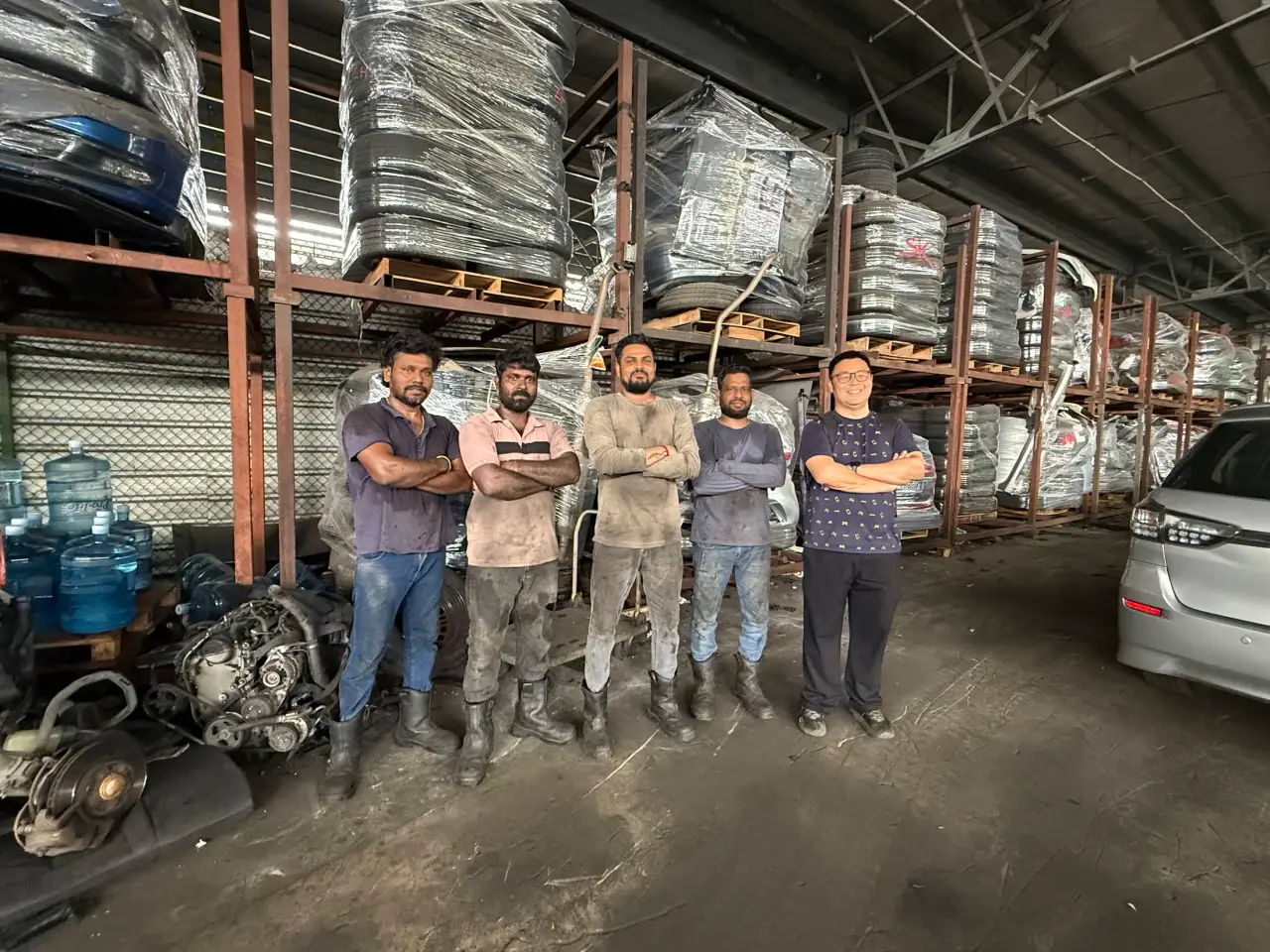 The Everise Auto team standing together in the vehicle parts warehouse